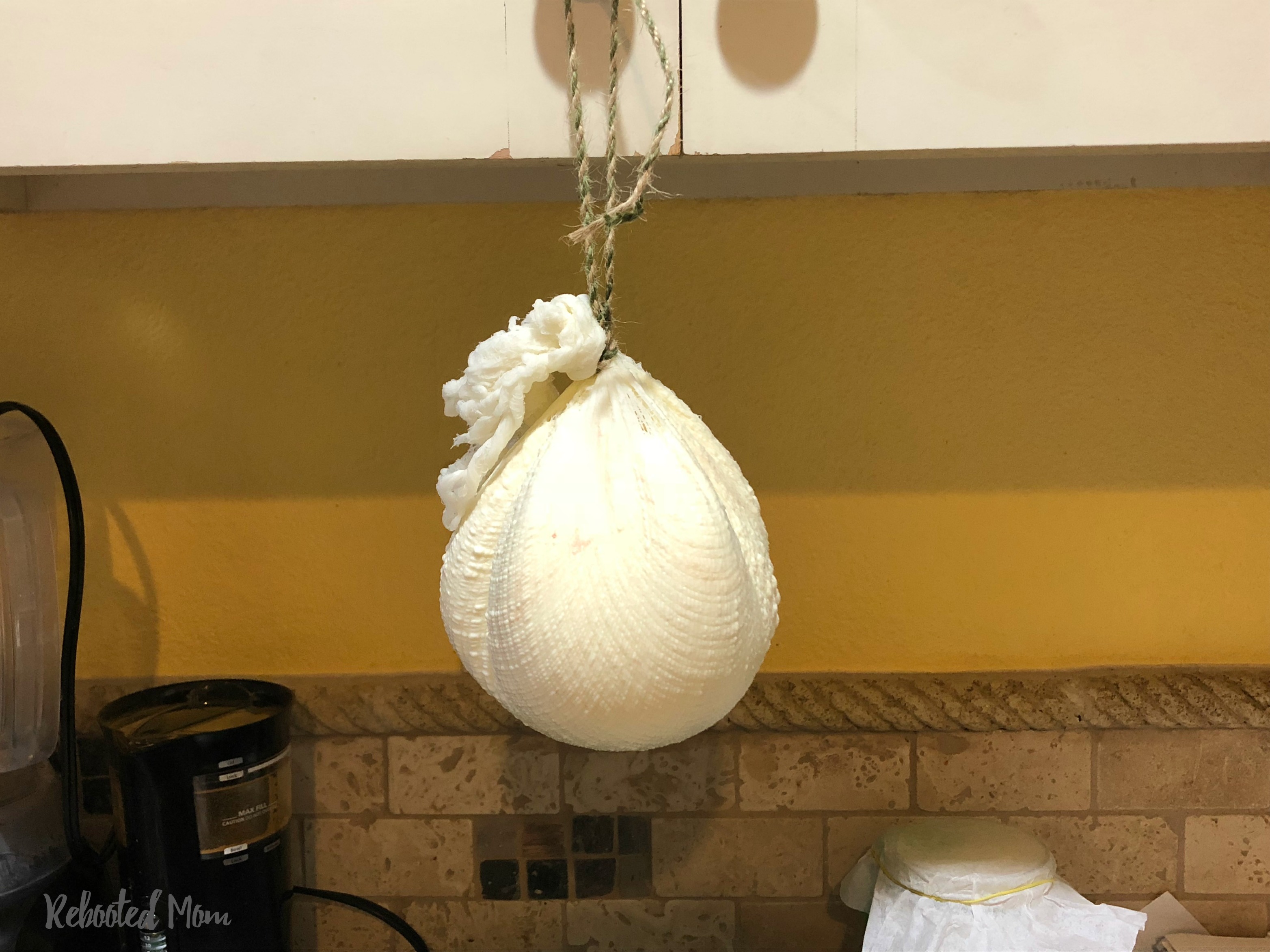 Cheese hanging from the cabinets to release whey