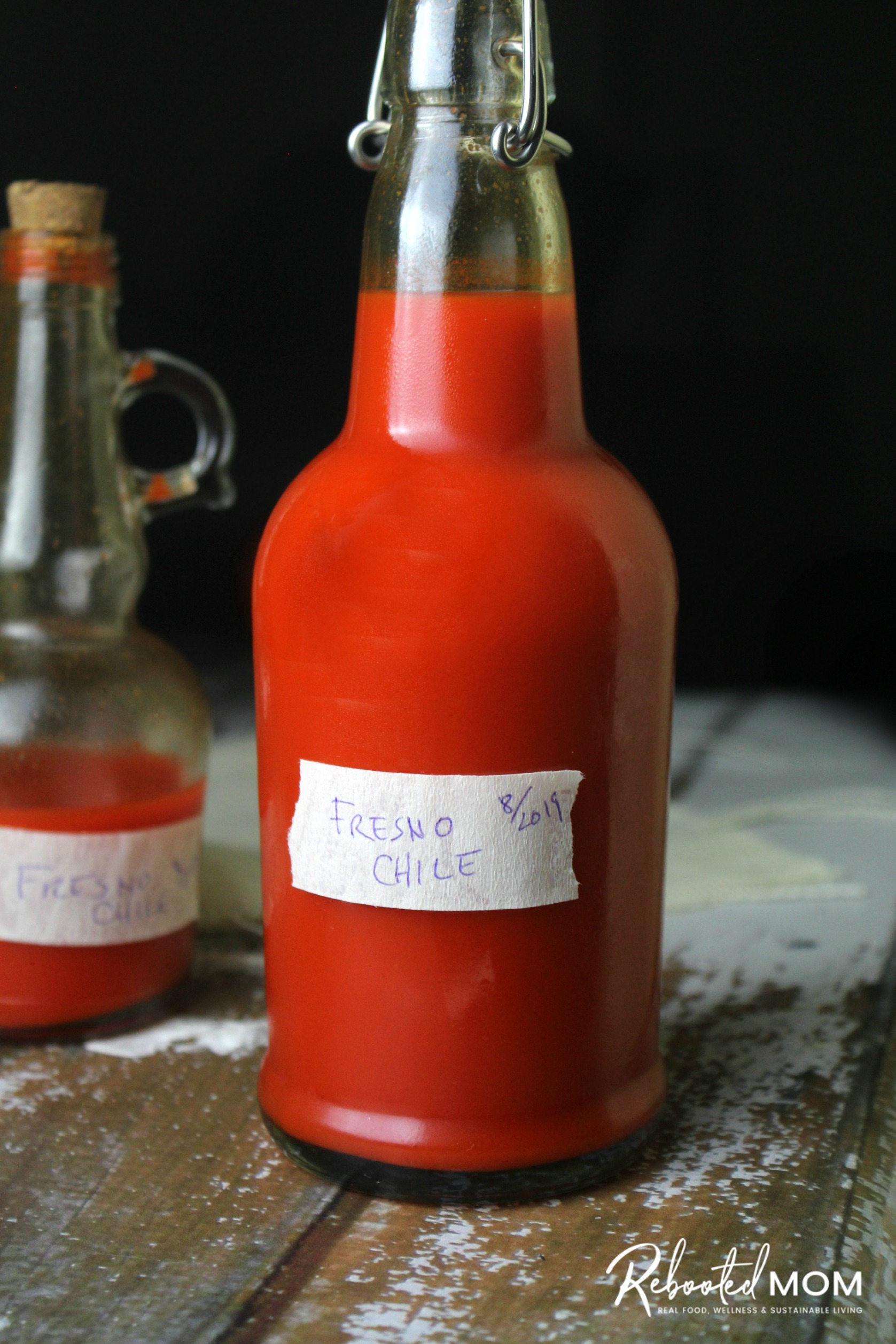 Homemade fermented Fresno pepper hot sauce in a swing top bottle