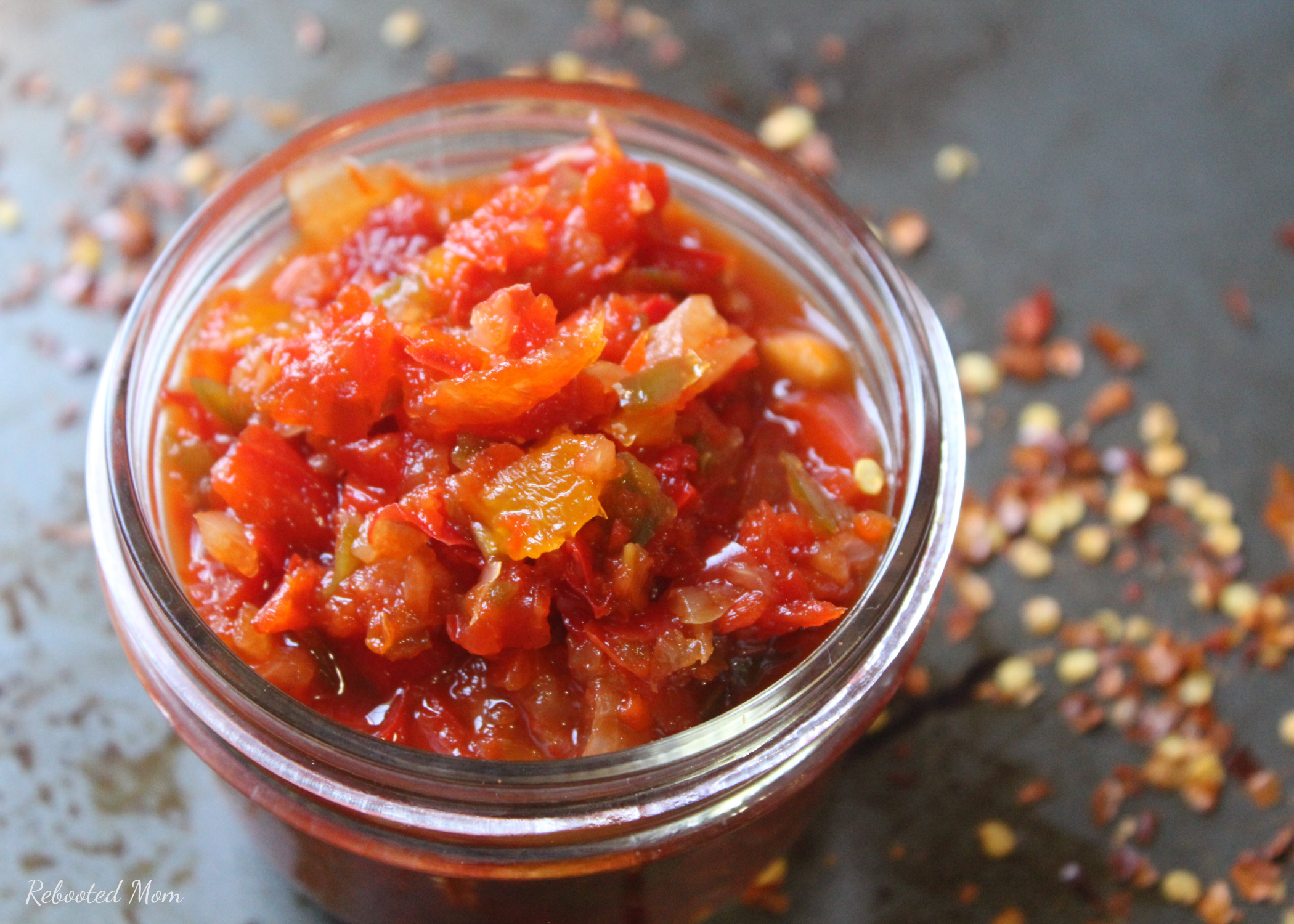 Spicy Tomato Chutney combines garden fresh tomatoes with peppers, onions and spices for a chutney that's perfect topped on seafood, steak or on your next cheeseboard!